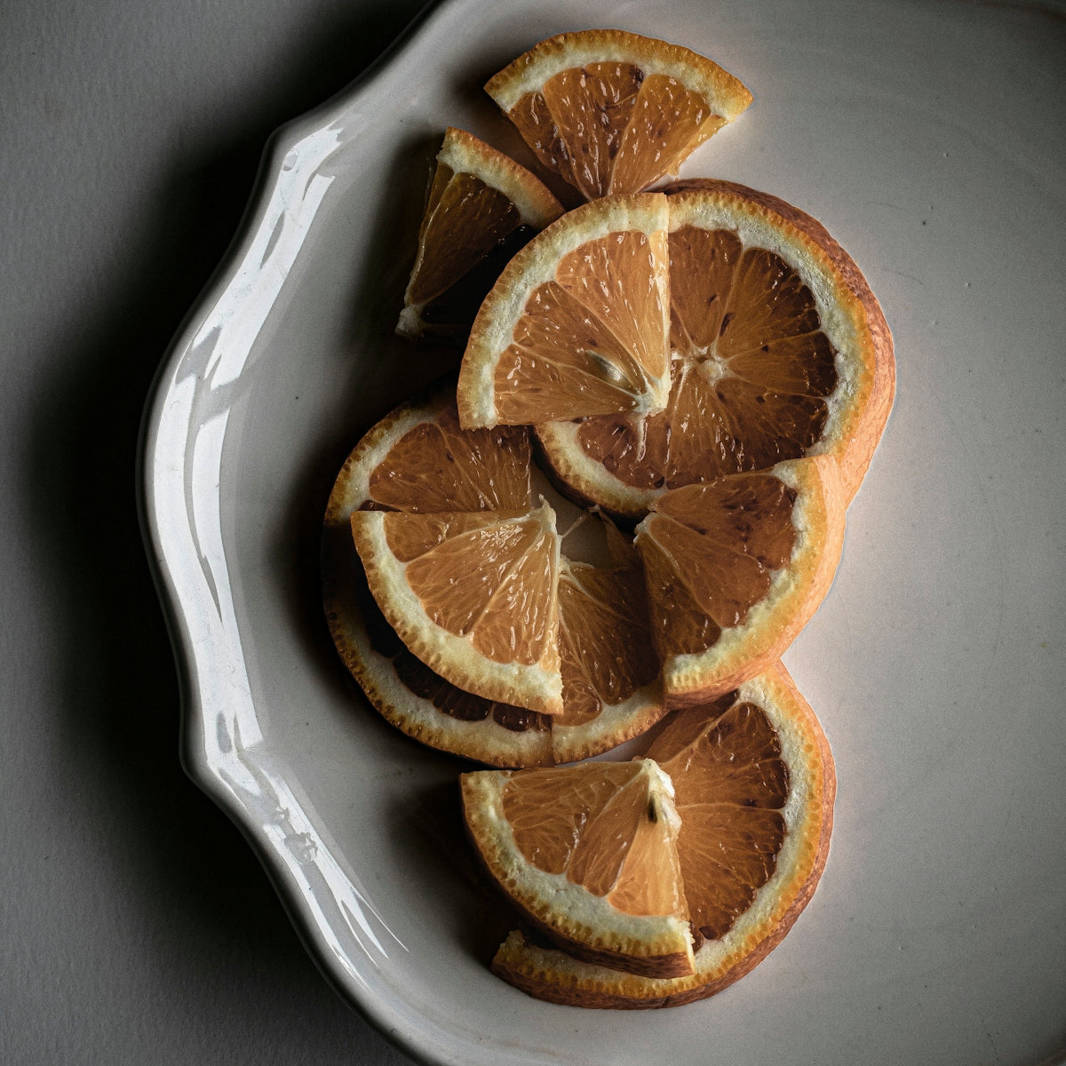 a white plate topped with sliced oranges on top of a table